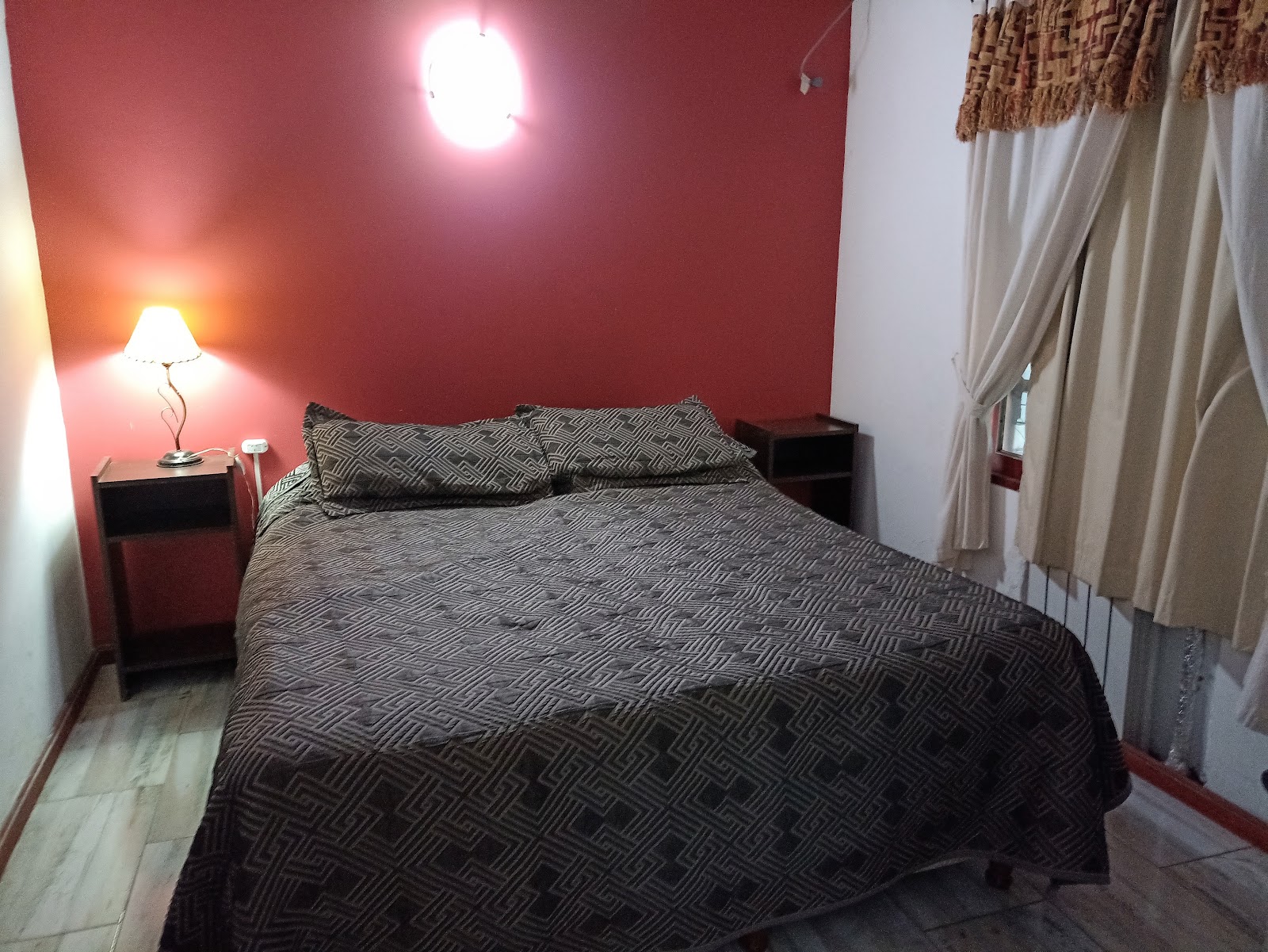Habitación doble del Hotel Jardín del Lago con cama amplia y mesas de luz